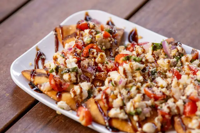 Bruschetta-topped chips drizzled with balsamic
