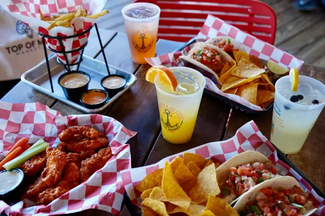 Wings, tacos, fries and crushes on a table