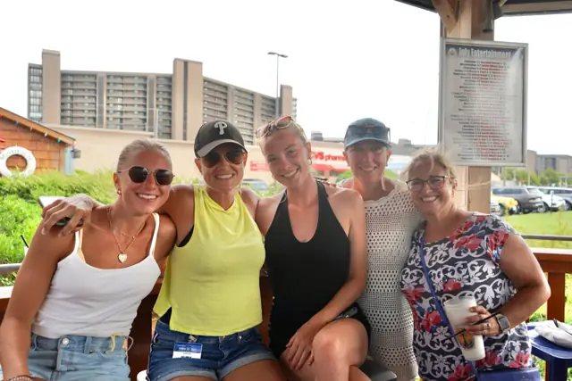 Five friends smiling on the covered deck