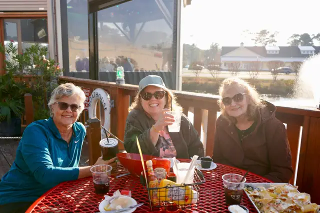 Three friends on the deck by the fountain at golden hour